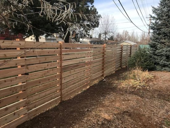 Commercial horizontal wooden fence installed near homes